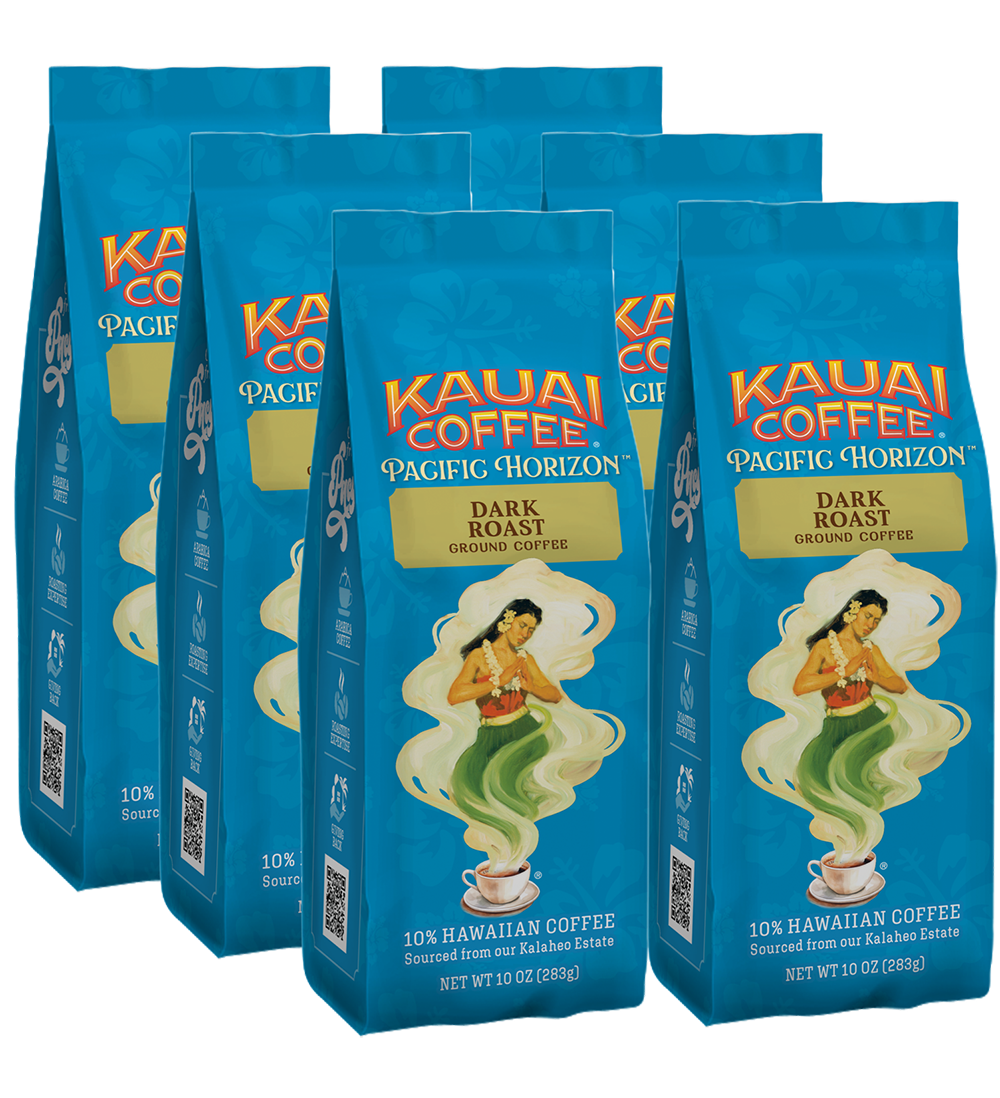 Six 10 oz (283g) bags of Kauai Coffees Dark Roast Ground Coffee are displayed, featuring a green-clad woman with a steaming cup against waves and a sunset, made from premium Arabica beans.